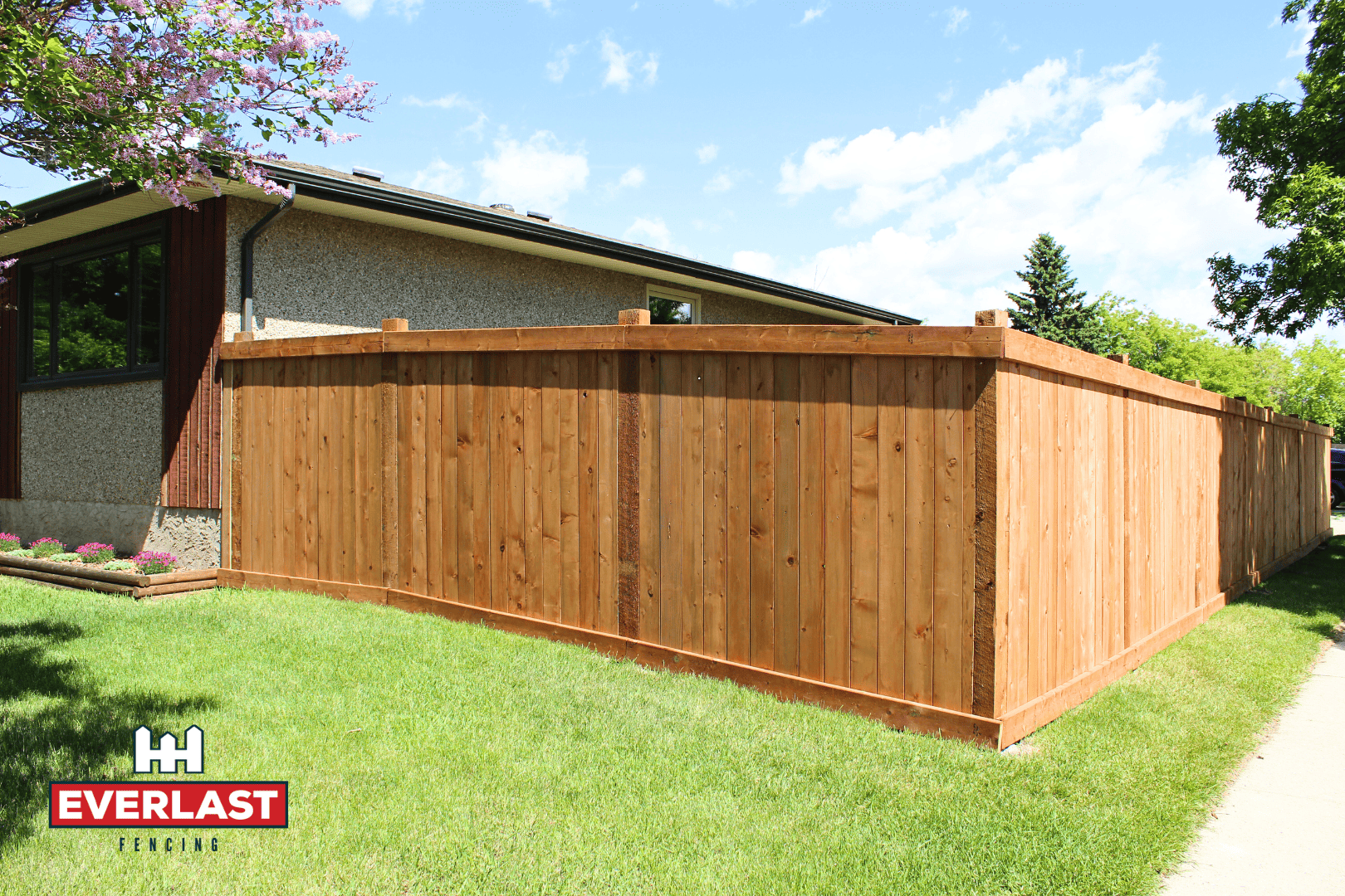 A picturesque wood fence surrounds a charming house, adding warmth and character to the outdoor space. The fence features well-maintained wooden panels, showcasing the natural grain and rich color of the wood.