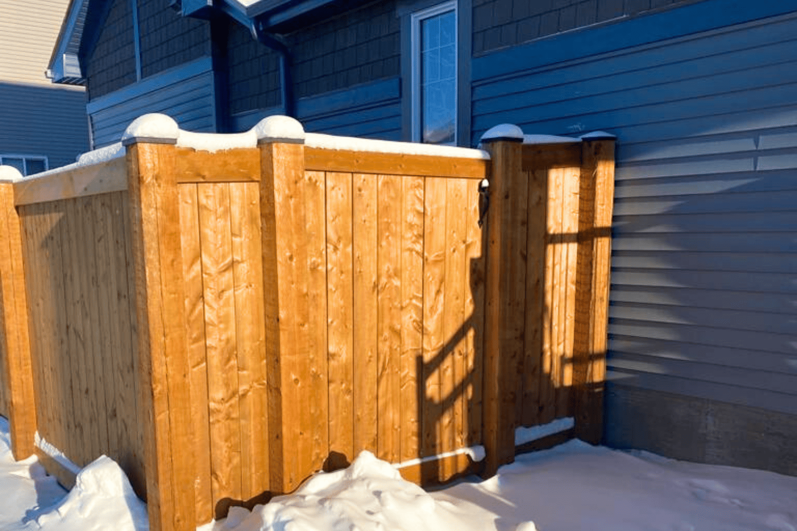 A winter wood fence covered in snow with potential vulnerabilities.